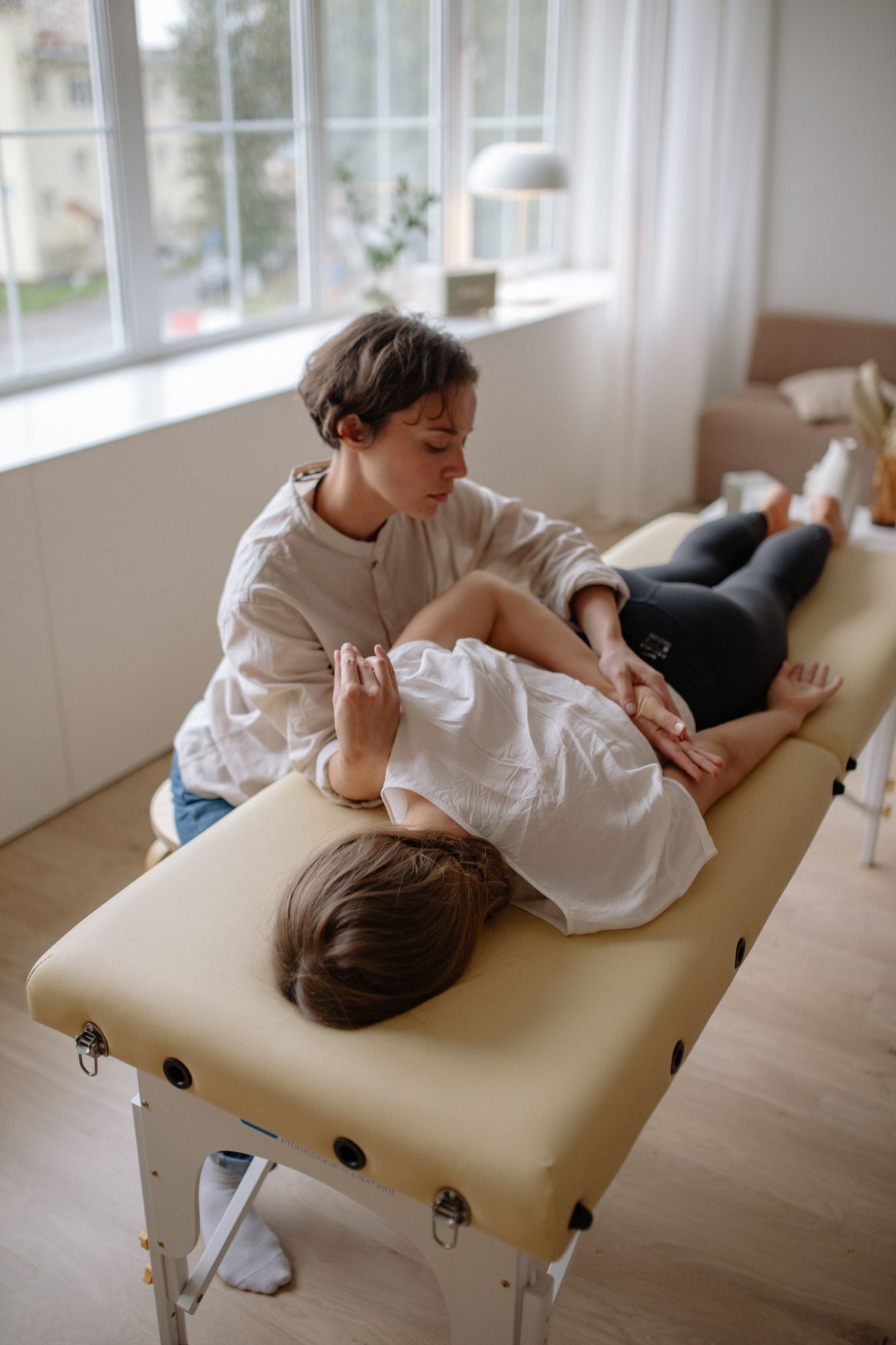 Therapist working on a patient's lower back on a treatment table