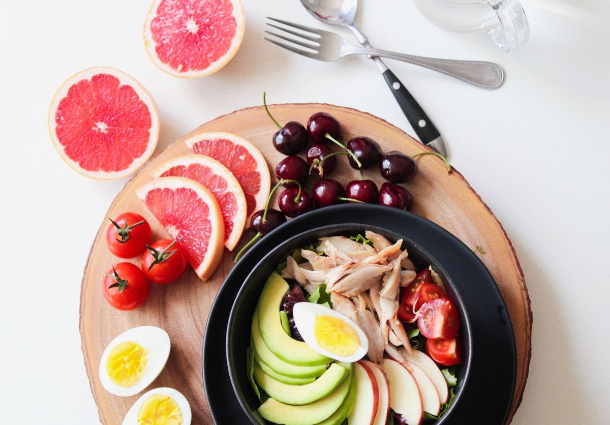 Bowl of mixed greens with avocado, egg, tomatoes and grapefruit